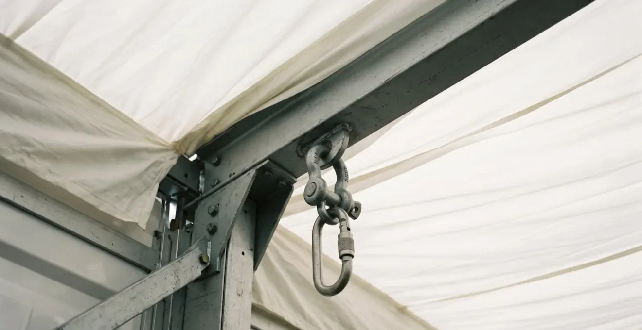 Marquee ceiling rigging point junction showing professional structural hardware and load-bearing beam connection